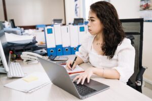 Perempuan sedang bekkerja didepan komputer